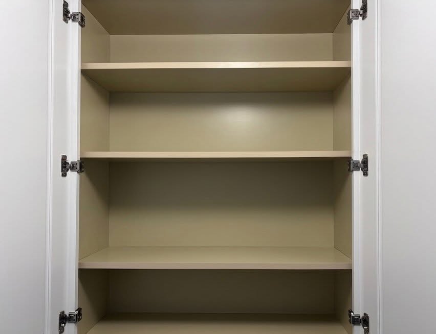 Interior of a custom cabinet with adjustable shelving on a drilled panel system