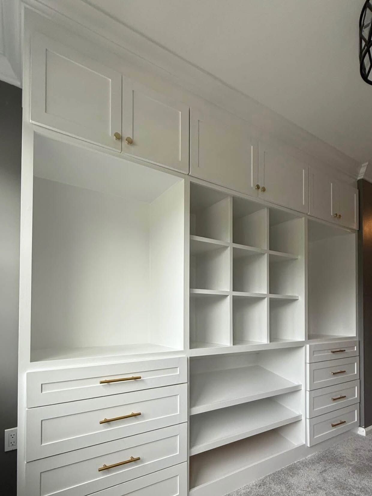 Custom closet wall with shoe cubbies, drawer banks and hanging sections in a Marlboro NJ home