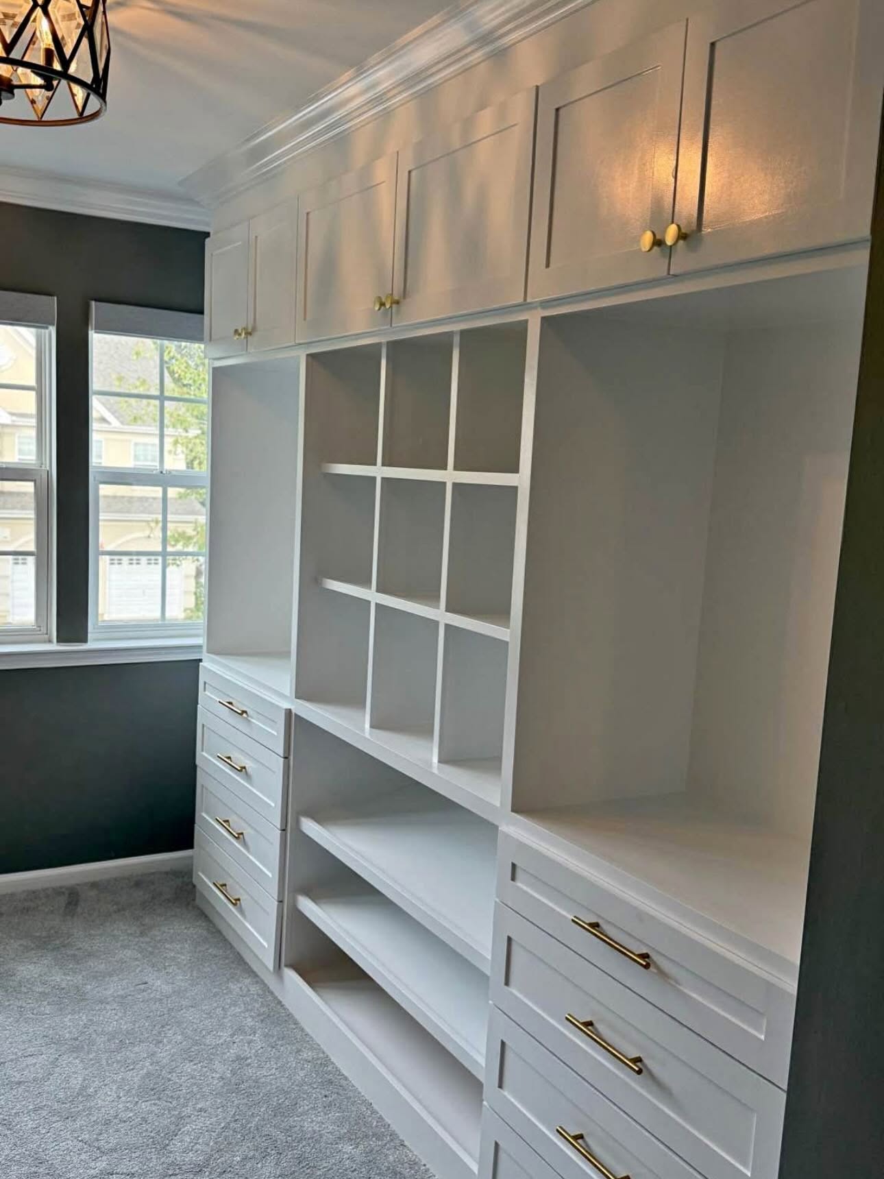 Custom walk-in closet with shaker drawers, cubbies and brass hardware