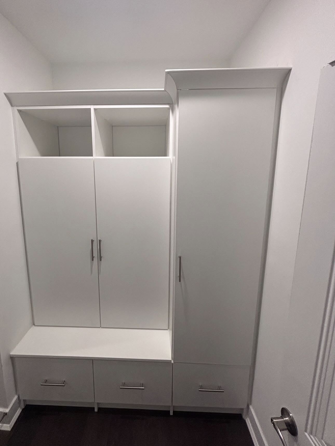 Built-in entryway cabinet in white with bench seating and closed storage