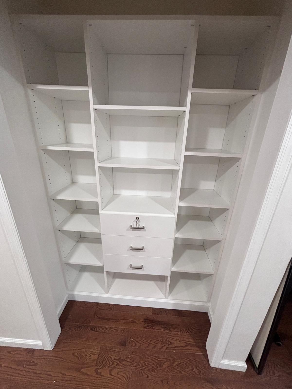 Custom reach-in closet with a drawer tower, adjustable shelving and double hanging in a New Jersey bedroom