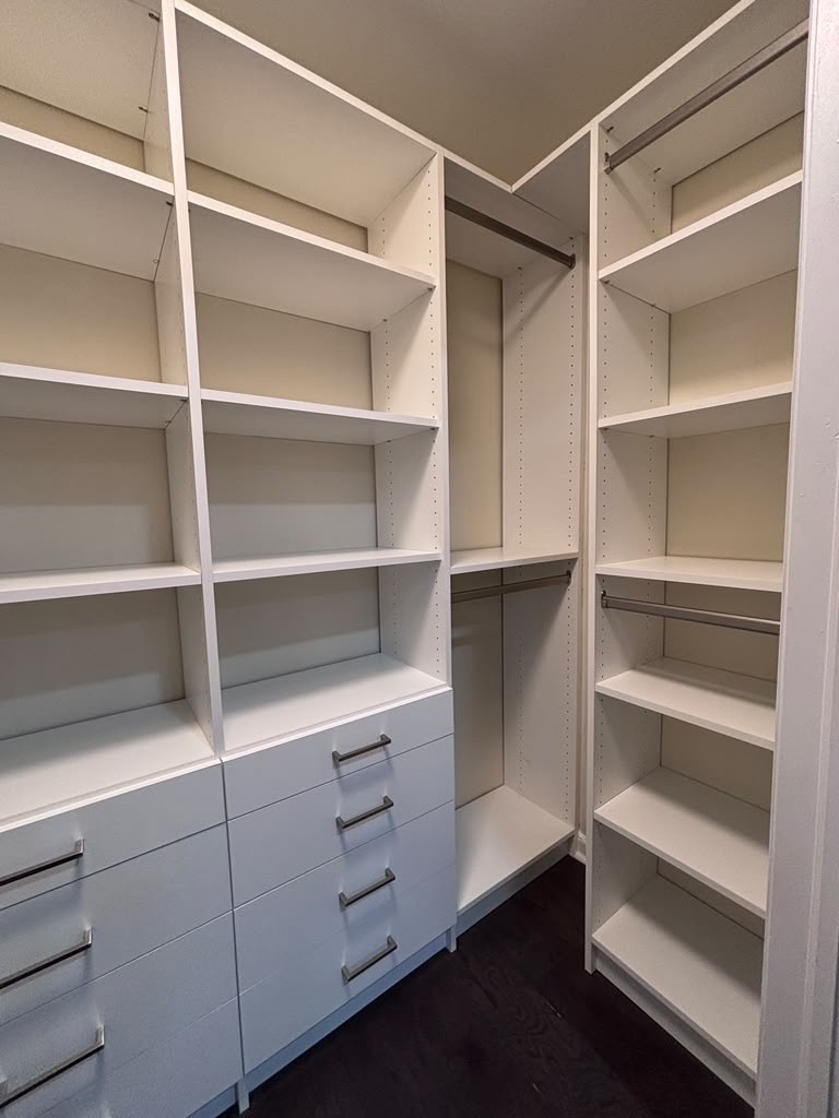 Walk-in closet corner fitted with shelving, drawers and hanging space