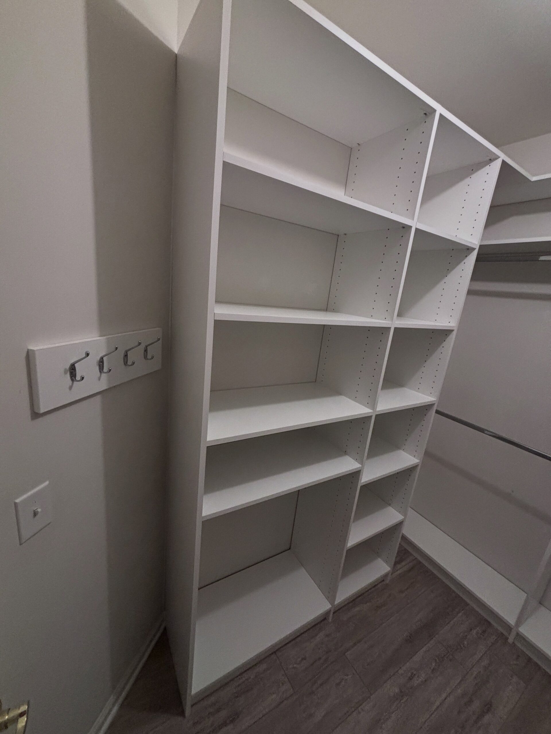 Corner closet shelving with hanging rod and wall hooks