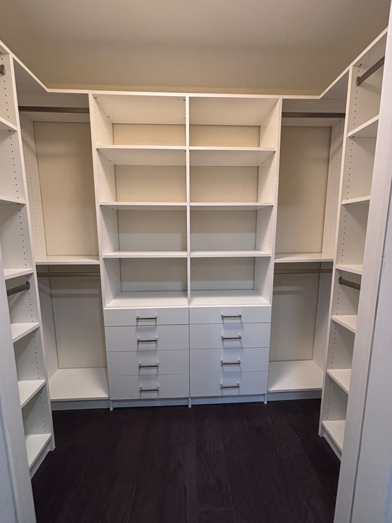 Walk-in closet with twin drawer banks, hanging sections and shelving above