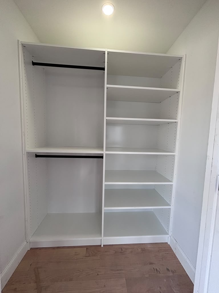 Custom reach-in closet with double hanging rods and a six-shelf adjustable tower