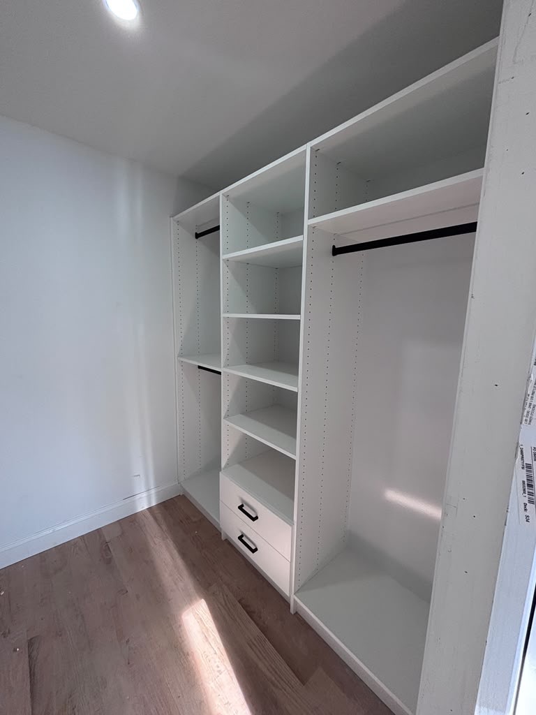 Walk-in closet with a central shelf tower and double hanging